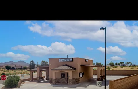 Completed tan commercial building with a covered entrance and landscaped parking area